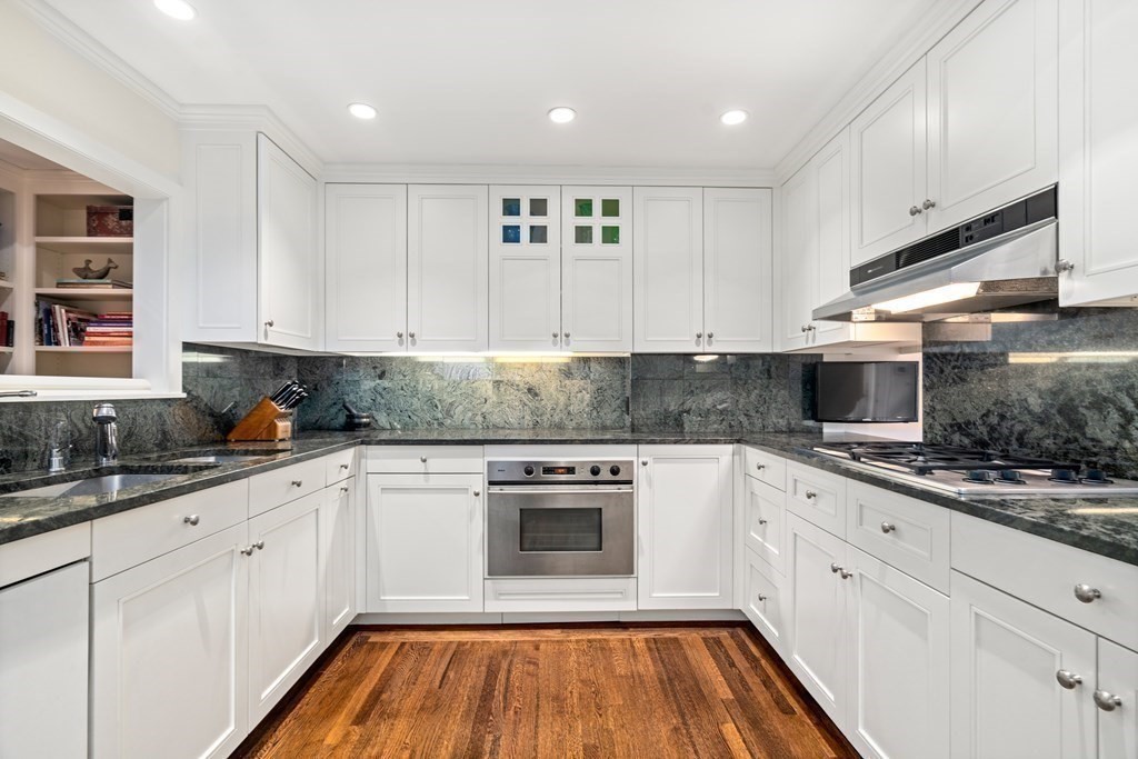 17 West Cedar Street Boston, MA 02108 - Photo 17 of 42 a kitchen with granite countertop white cabinets and white appliances