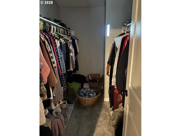 a view of walk in closet with clothes and shoes