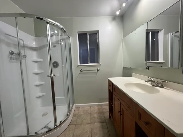 a bathroom with a shower sink and mirror