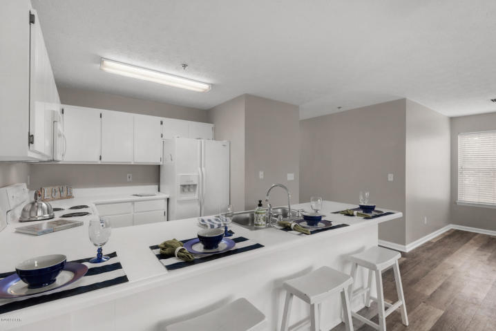 17690 Front Beach Road, Unit D207 Panama City Beach, FL 32413 - Photo 11 of 28 a kitchen with stainless steel appliances a sink a stove and white cabinets