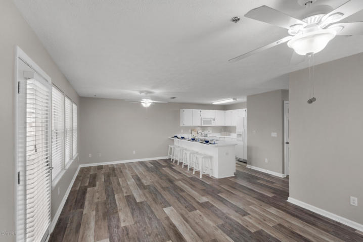 17690 Front Beach Road, Unit D207 Panama City Beach, FL 32413 - Photo 5 of 28 a kitchen with a sink dishwasher a stove and a refrigerator with wooden floor