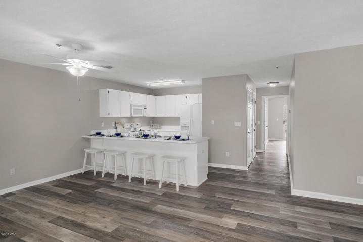 17690 Front Beach Road, Unit D207 Panama City Beach, FL 32413 - Photo 8 of 28 a view of a kitchen with kitchen island stainless steel appliances refrigerator stove and wooden floor