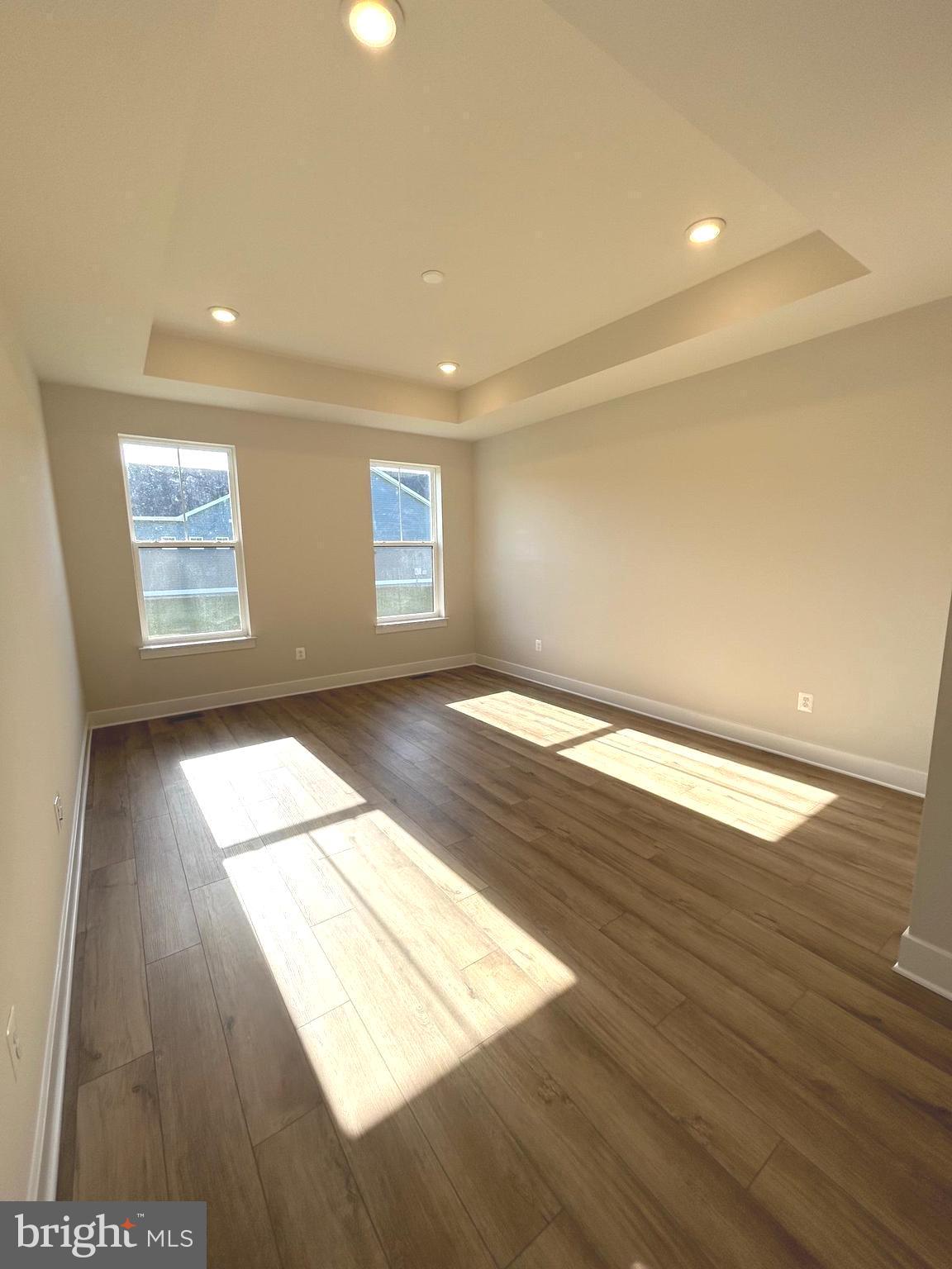30078 Chase Oaks Drive Lewes, DE 19958 - Photo 8 of 17 an empty room with wooden floor and windows