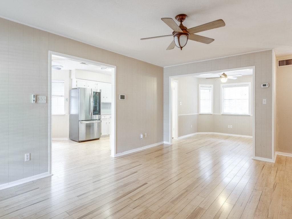 a view of empty room with wooden floor and a ceiling fan