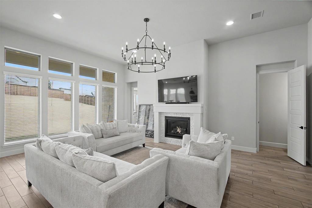 116 Derrett Lane Rhome, TX 76078 - Photo 6 of 30 a living room with furniture a chandelier and a fireplace