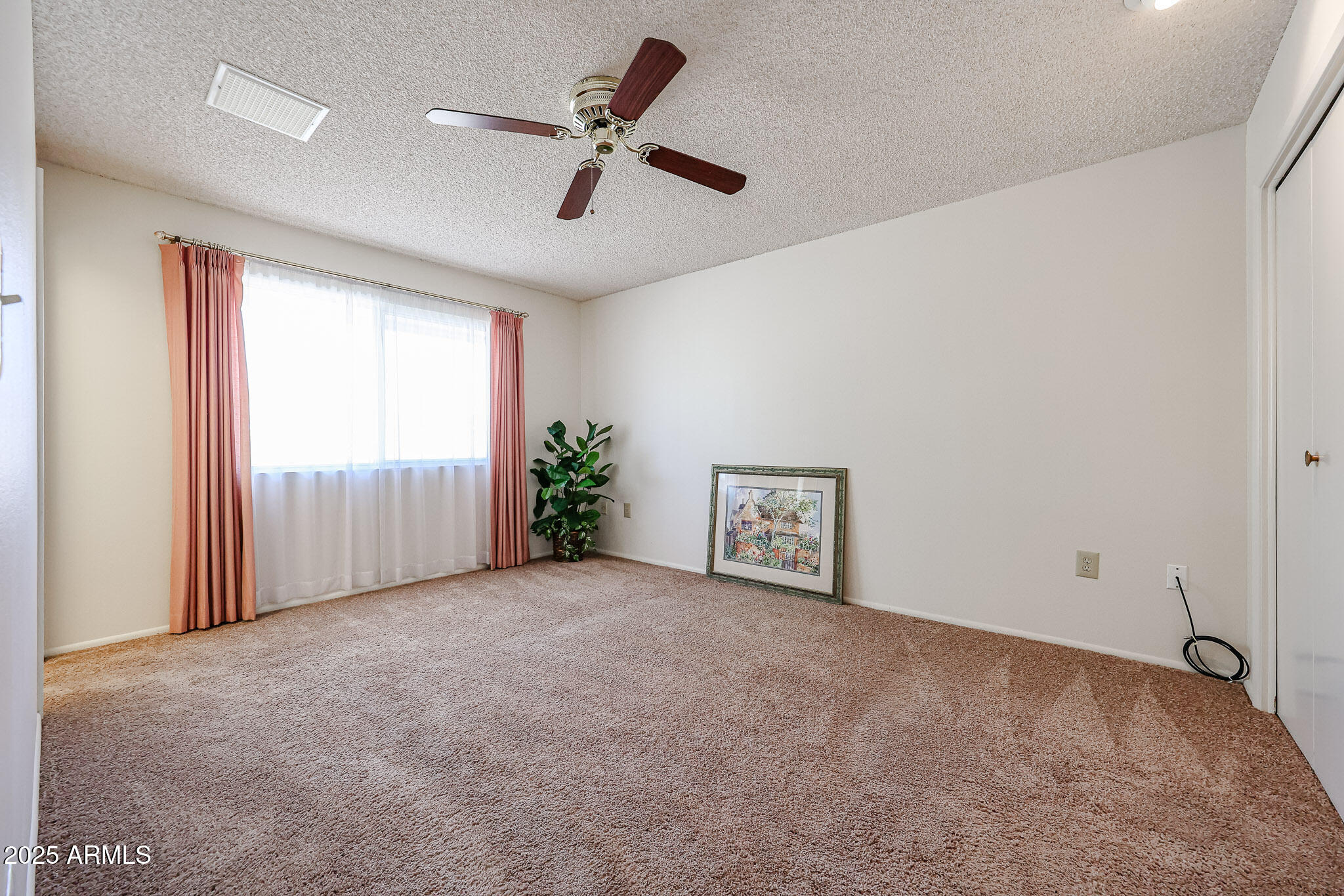 10326 West Pleasant Valley Road Sun City, AZ 85351 - Photo 9 of 25 an empty room with windows and ceiling fan