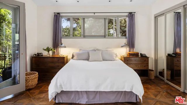 a bedroom with a bed and a large window