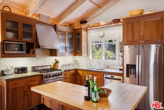 a kitchen with stainless steel appliances granite countertop a sink a stove and a refrigerator