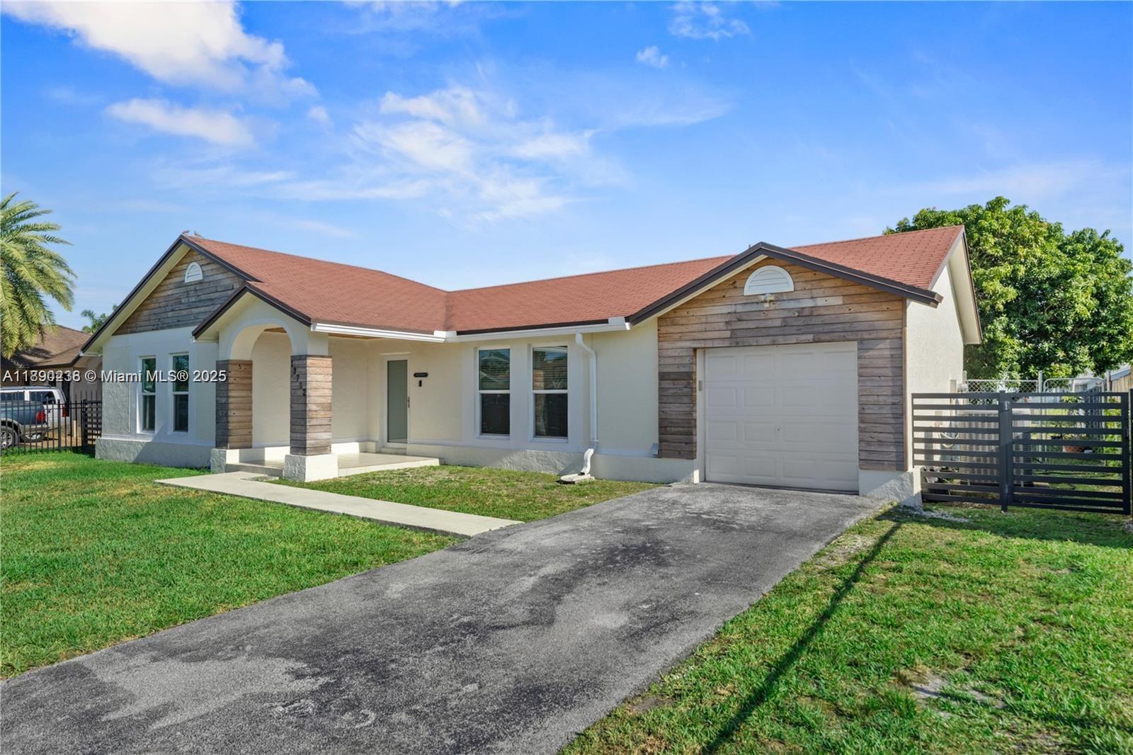13752 Southwest 285th Street Homestead, FL 33033 - Photo 3 of 25 a front view of a house with a yard and garage