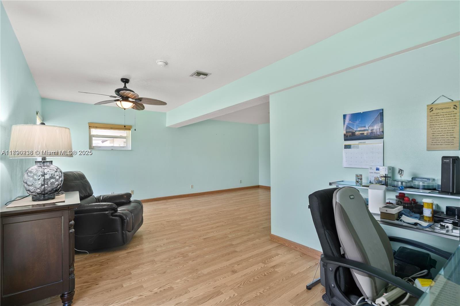 13752 Southwest 285th Street Homestead, FL 33033 - Photo 5 of 25 a view of a workspace with furniture and a wooden floor
