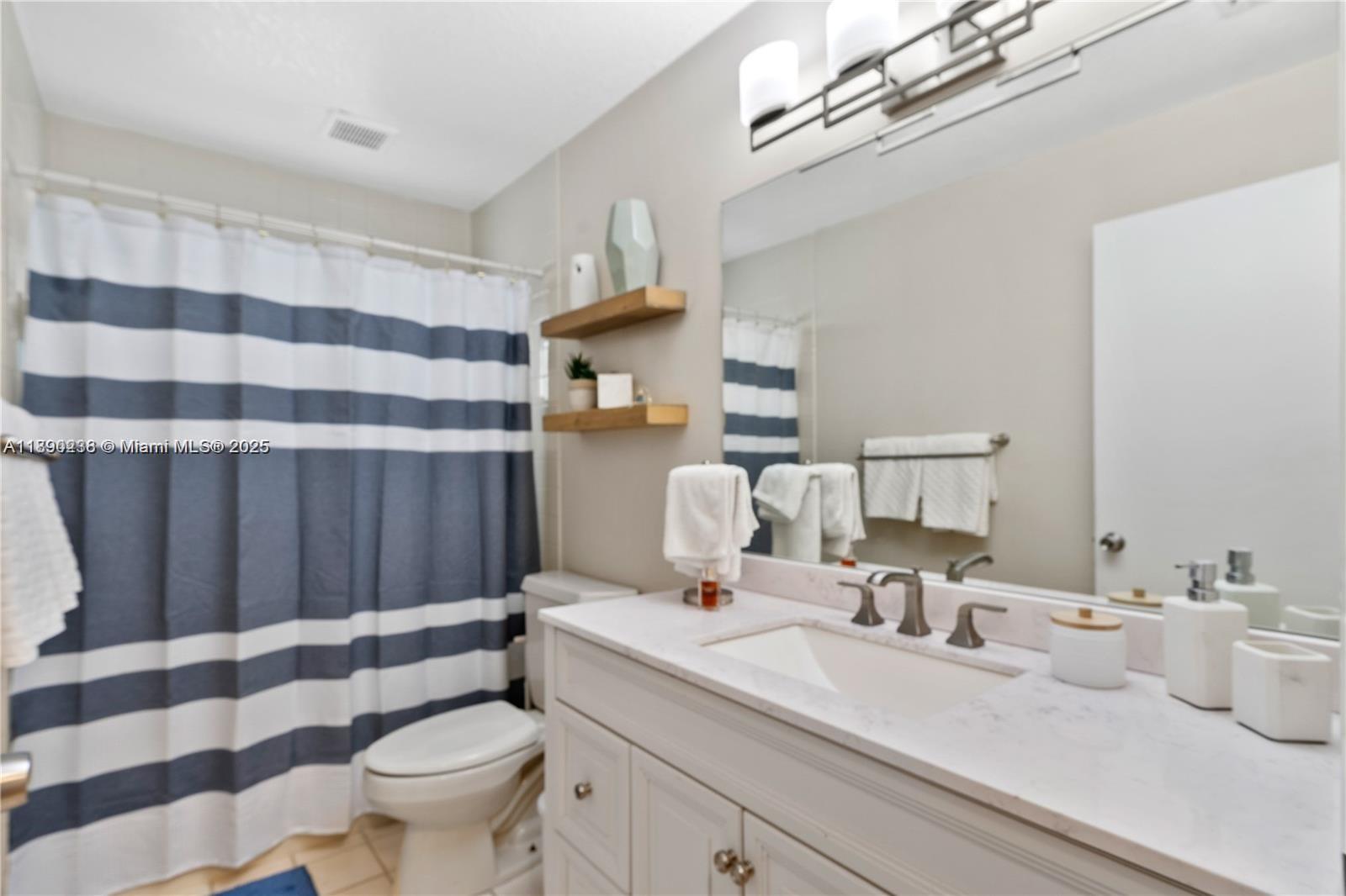 13752 Southwest 285th Street Homestead, FL 33033 - Photo 8 of 25 a bathroom with a sink toilet a mirror and shower curtain