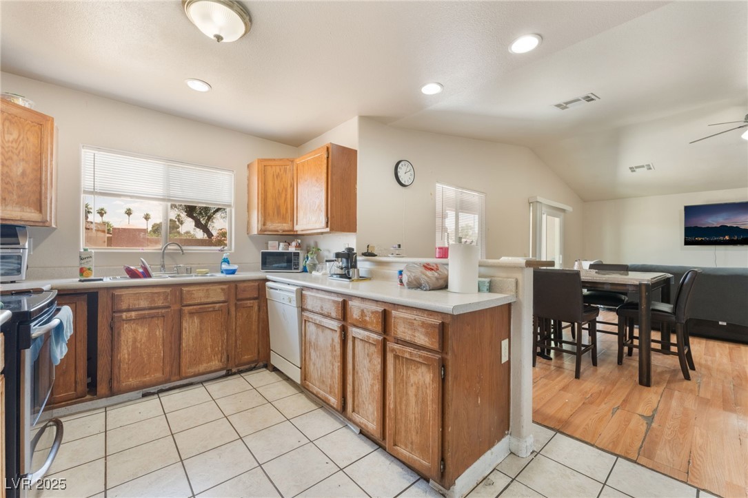 4656 East Desert Inn Road Las Vegas, NV 89121 - Photo 97 of 98 4650 E DI Kitchen with white dishwasher, open floor plan, a peninsula, black microwave, and electric stove