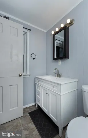 a bathroom with a sink a toilet a mirror and shower