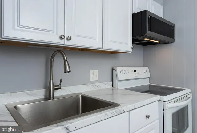 a kitchen with stainless steel appliances granite countertop a sink and a microwave