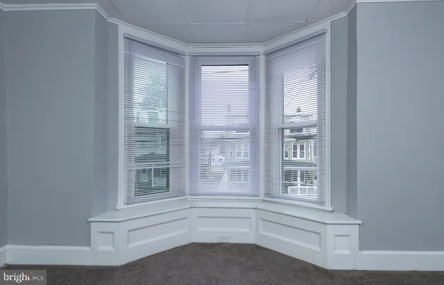 a view of empty room with window and cabinet