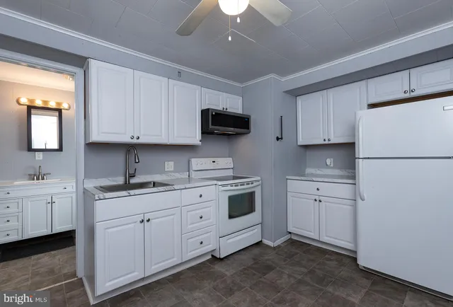 a kitchen with white cabinets sink and white appliances