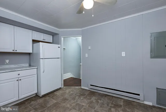 a view of a kitchen with cabinets and refrigerator