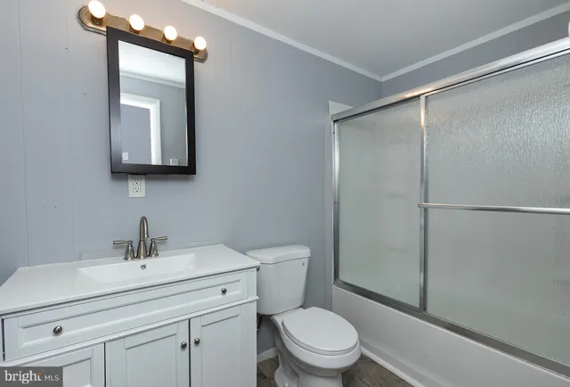 a bathroom with a toilet a sink a mirror and vanity