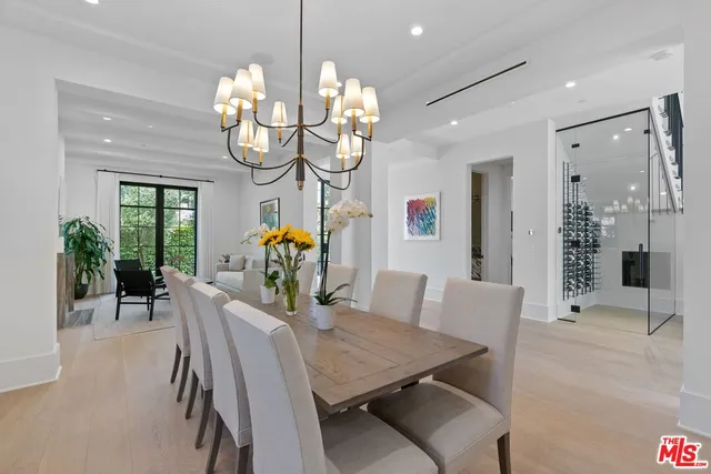 a dining room filled chandelier and wooden floor