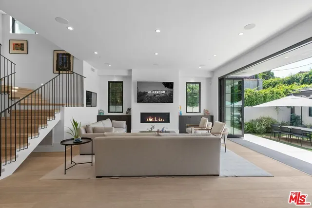 a living room with fireplace furniture and a large window
