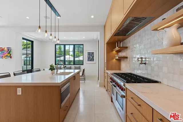 a kitchen with stainless steel appliances a sink stove and cabinets
