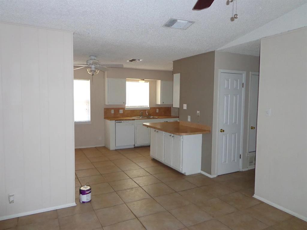 4004 Vicky Street Big Spring, TX 79720 - Photo 12 of 13 Kitchen featuring white cabinetry, light-tone countertops, and a tile backsplash