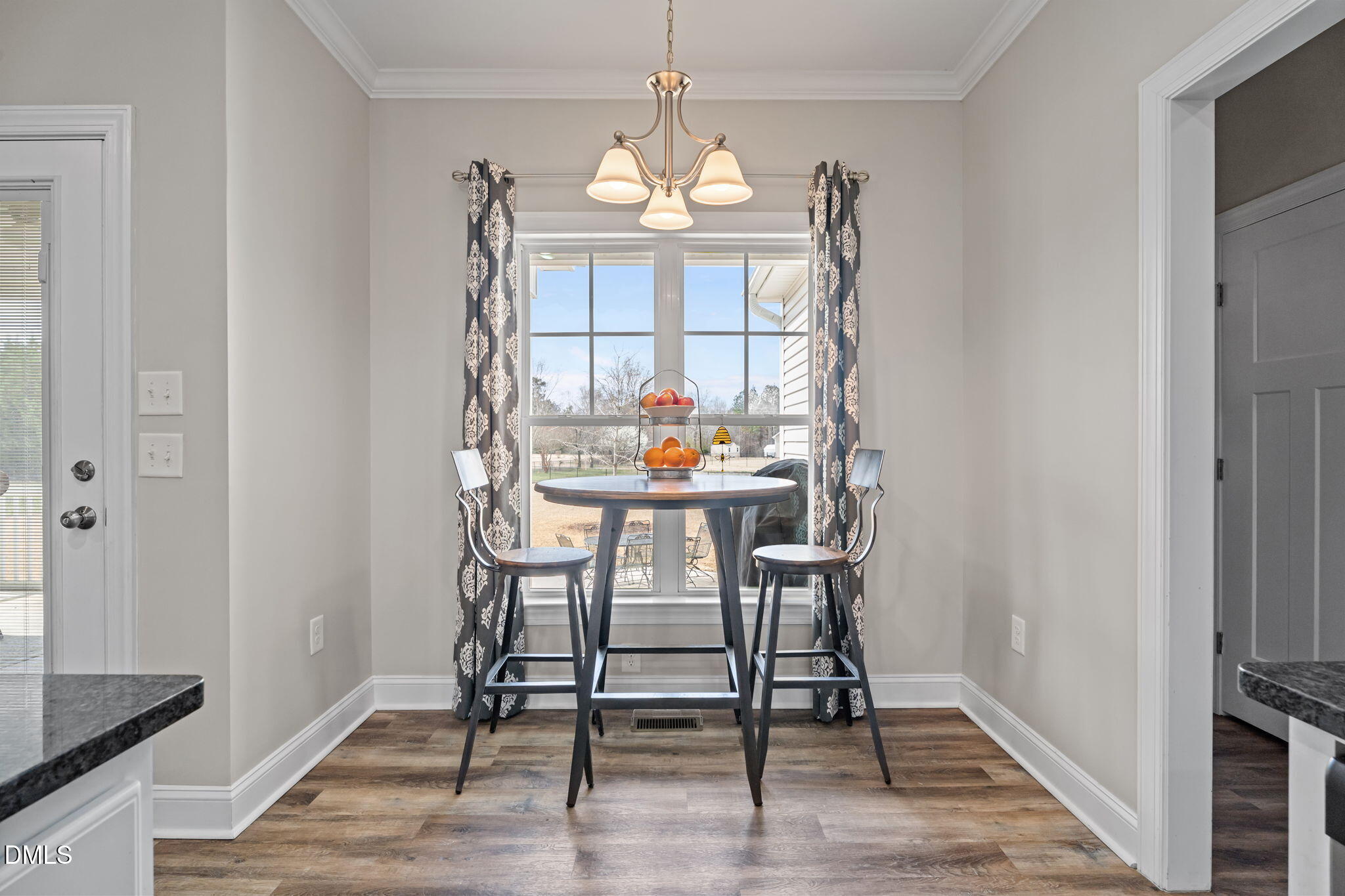 8772 Surrey Top Road Bailey, NC 27807 - Photo 14 of 42 a dining room with wooden floor a chandelier a wooden table and chairs