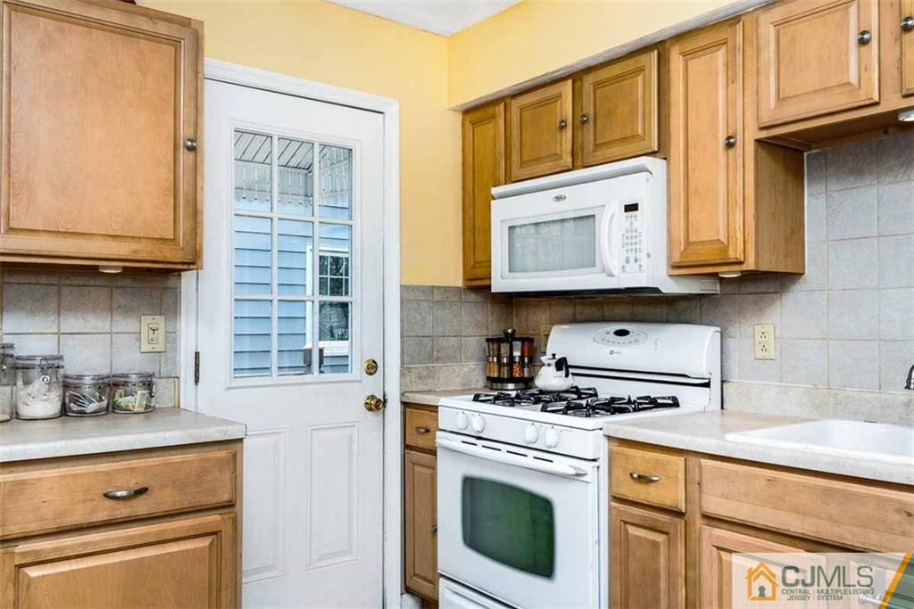 310 Howard Avenue Middlesex, NJ 08846 - Photo 4 of 25 a kitchen with granite countertop a stove a sink and a microwave