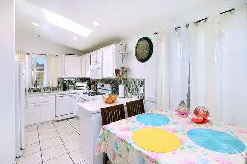 a kitchen with a sink a stove and a dining table