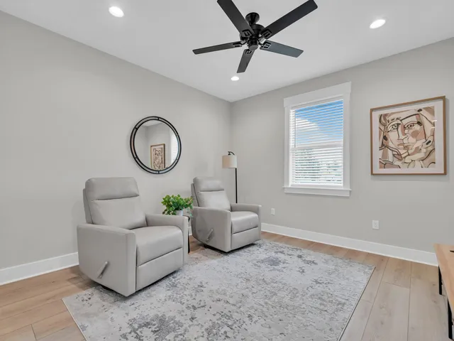 a living room with furniture and a ceiling fan