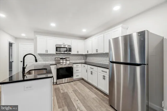 a kitchen with stainless steel appliances a refrigerator stove microwave and sink