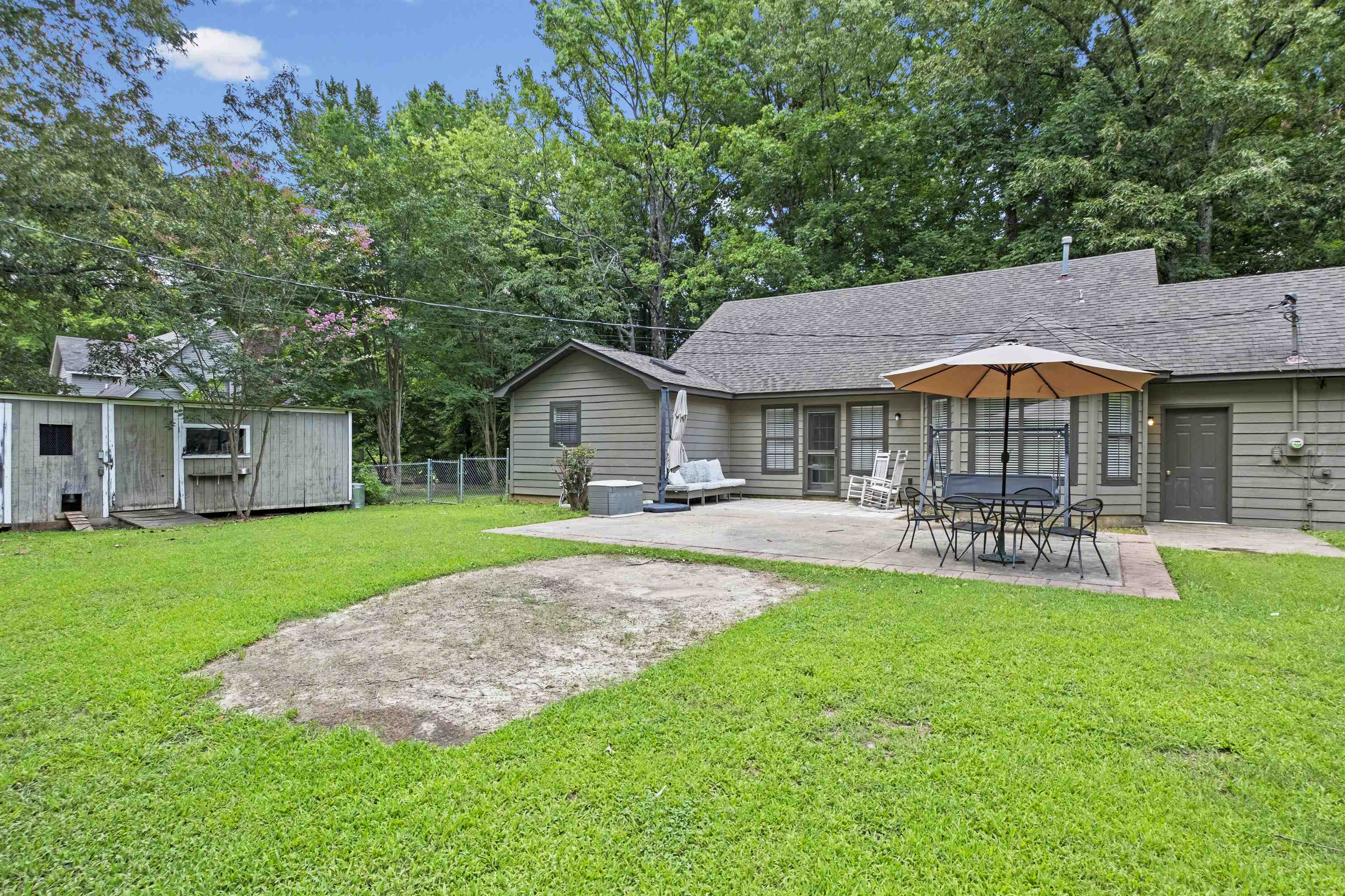 3601 Marshall Road Munford, TN 38058 - Photo 11 of 35 Expansive backyard featuring a concrete patio, mature trees, and a separate shed structure