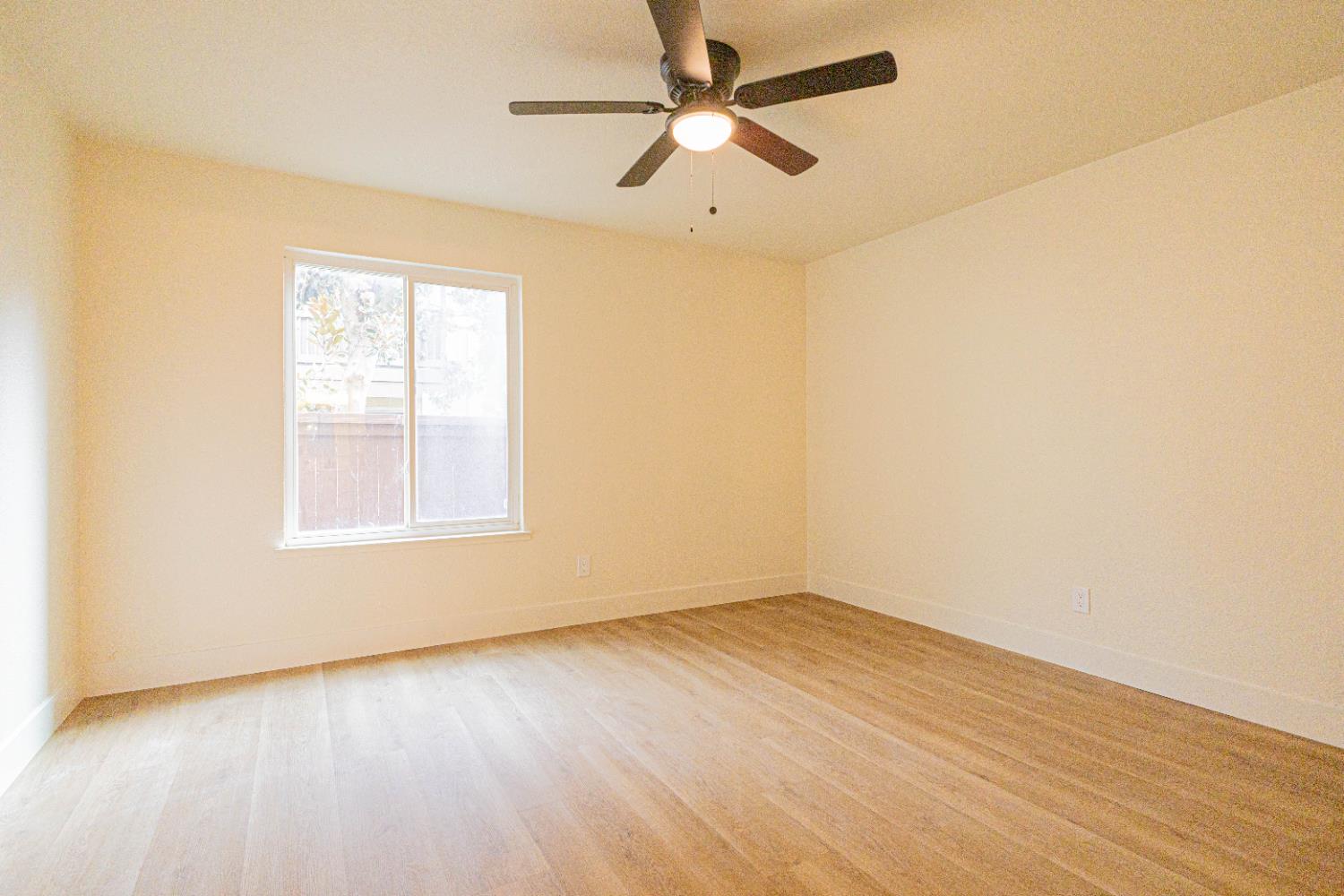 2909 Huntington Boulevard, Unit 107 Fresno, CA 93721 - Photo 5 of 9 an empty room with wooden floor and windows