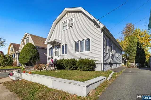 a view of a white house with a yard and plants
