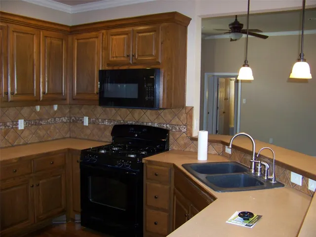 a kitchen with granite countertop a sink stainless steel appliances and cabinets