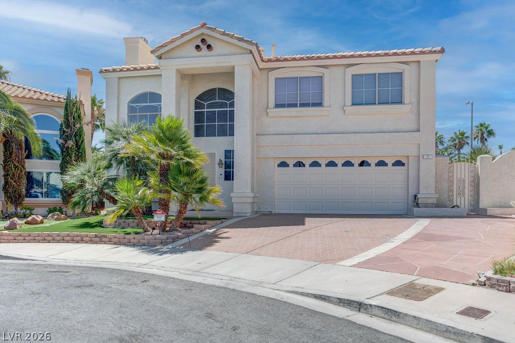 1 Rising Sun Court Henderson, NV 89074 - Photo 45 of 47 A grand two-story residence with a spacious driveway and tropical landscaping.