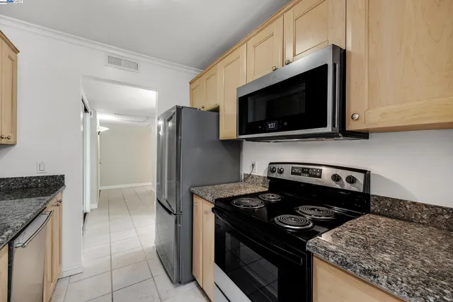 a kitchen with stainless steel appliances granite countertop a stove and a refrigerator