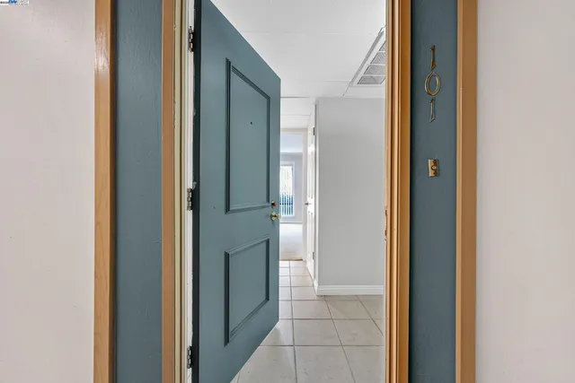 a view of a big room with windows and chandelier fan