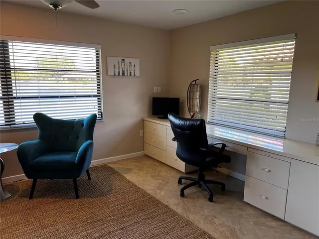 a view of a workspace with furniture and a window