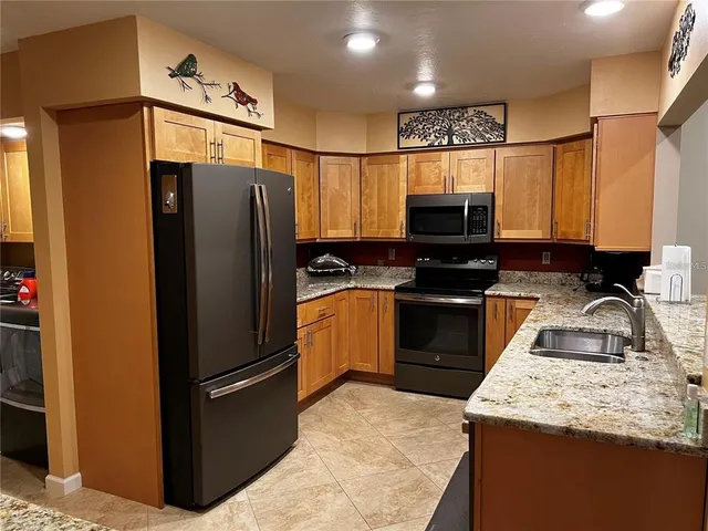 a kitchen with granite countertop a refrigerator and a sink