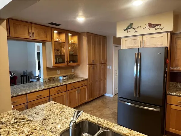 a kitchen with granite countertop a refrigerator and a sink