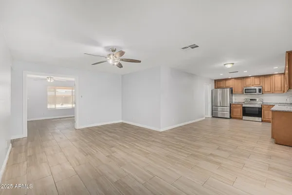 a view of empty room with wooden floor and window