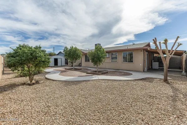 a view of a house with backyard and sitting area
