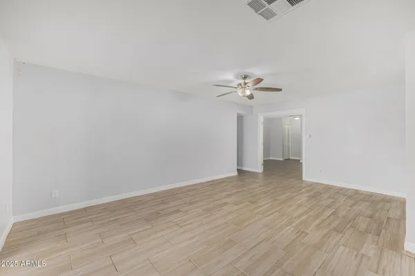 a view of a room with wooden floor and a ceiling fan