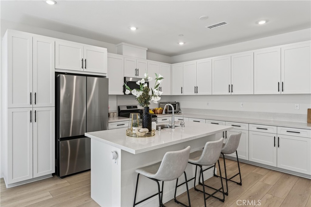 1572 Lima Way, Unit 6 Placentia, CA 92870 - Photo 13 of 36 a kitchen with stainless steel appliances white cabinets and wooden floor
