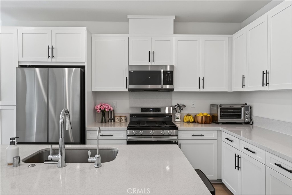 1572 Lima Way, Unit 6 Placentia, CA 92870 - Photo 15 of 36 a kitchen with stainless steel appliances granite countertop a stove a refrigerator and white cabinets