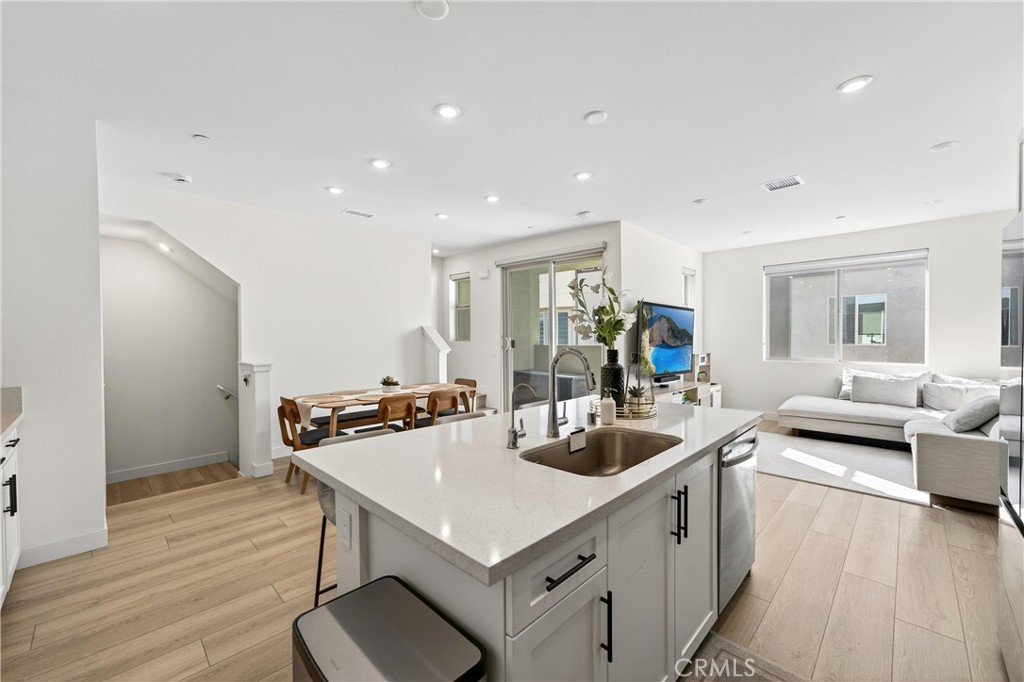 1572 Lima Way, Unit 6 Placentia, CA 92870 - Photo 17 of 36 a kitchen with a stove a refrigerator and a dining table with wooden floor