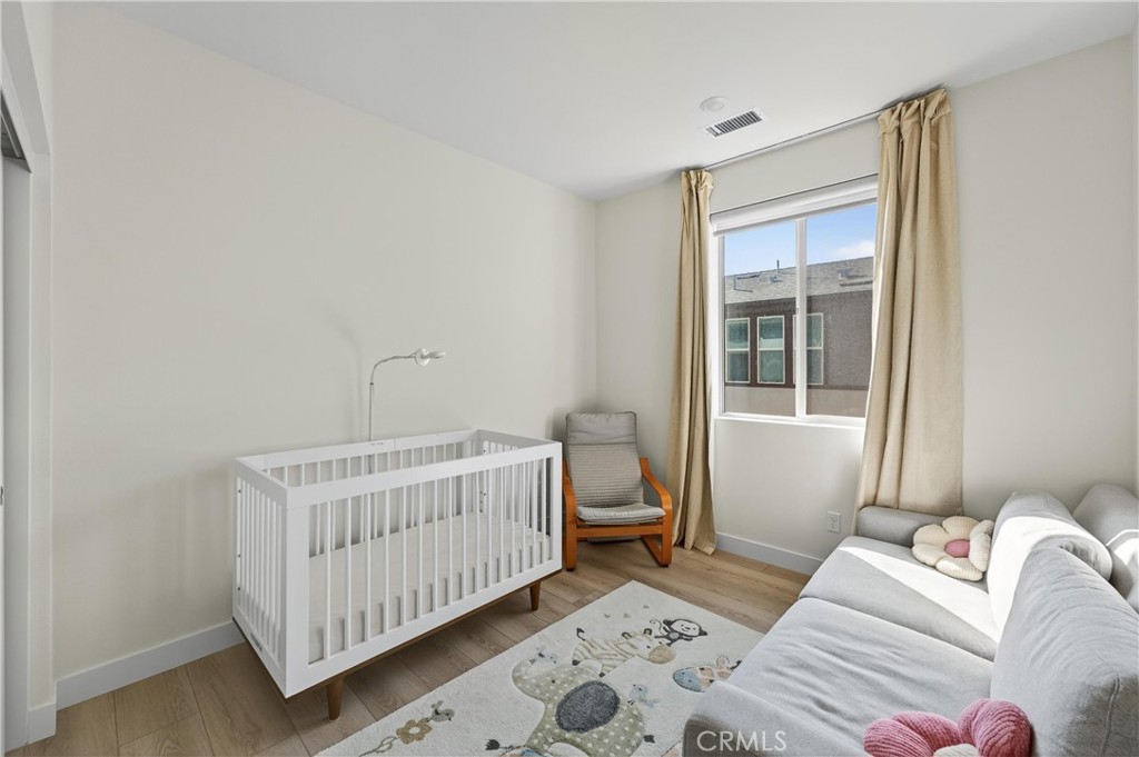 1572 Lima Way, Unit 6 Placentia, CA 92870 - Photo 21 of 36 a bedroom with a bed and wooden floor