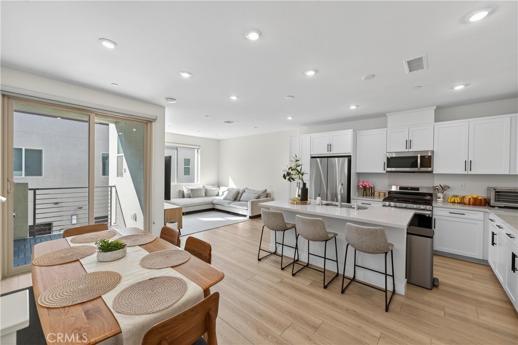 1572 Lima Way, Unit 6 Placentia, CA 92870 - Photo 3 of 35 a view of kitchen with stainless steel appliances granite countertop dining table chairs stove microwave and cabinets