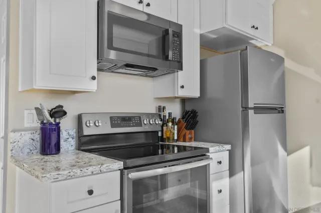 a kitchen with stainless steel appliances granite countertop a sink stove and microwave